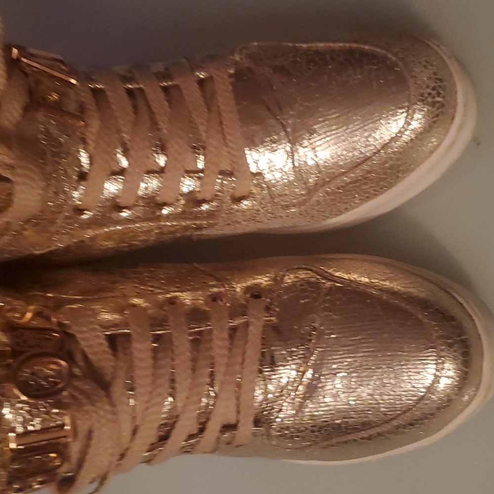Wedge gold sneakers with the letters spelling FABULOUS on the strap